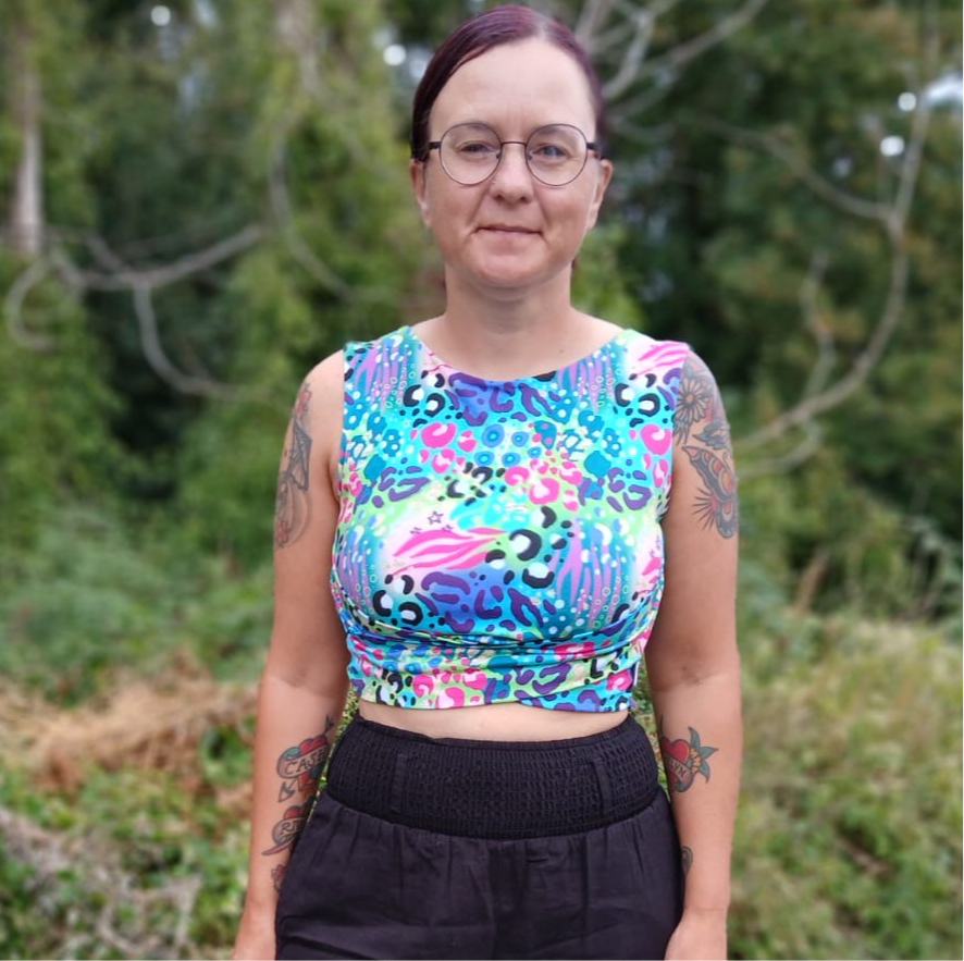 A person in a leopard print sleeveless cropped top with a crossover design under the chest
