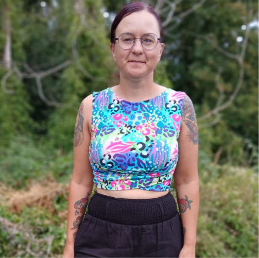 A person in a leopard print sleeveless cropped top with a crossover design under the chest